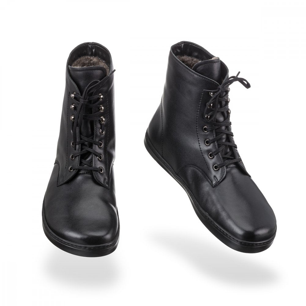 Barfußstiefel mit Schnürverschluss, breiter Zehenbox und flacher Sohle, geschlossener Fersenbereich, schräge Vorderansicht