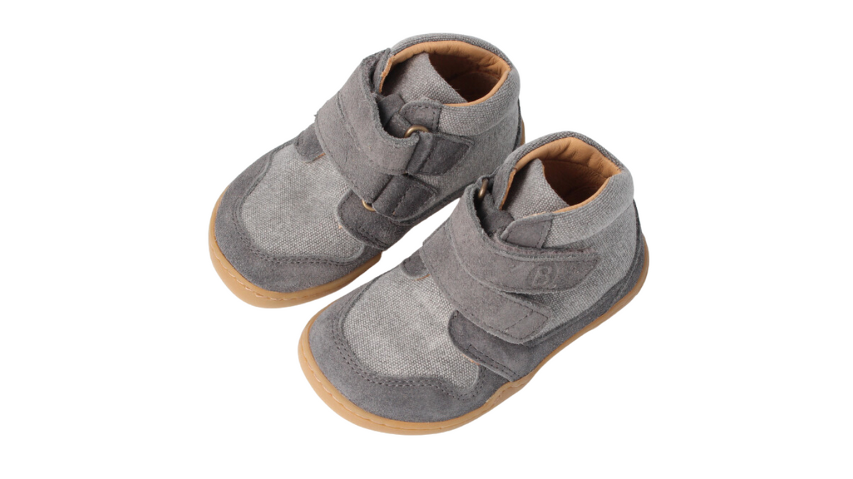 Knöchelhoher Barfußschuh für Erwachsene mit breiter Zehenbox, flexibler Sohle und Klettverschluss, geschlossener Zehenbereich und geschlossener Fersenbereich, schräge Vorderansicht als Paar.