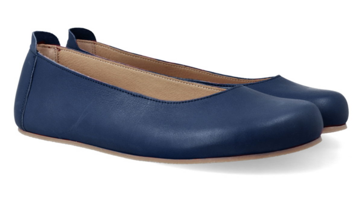 Ballerinas als Paar, schräge Vorderansicht. Glattes Leder, runde Zehenform, sehr flache Sohle.