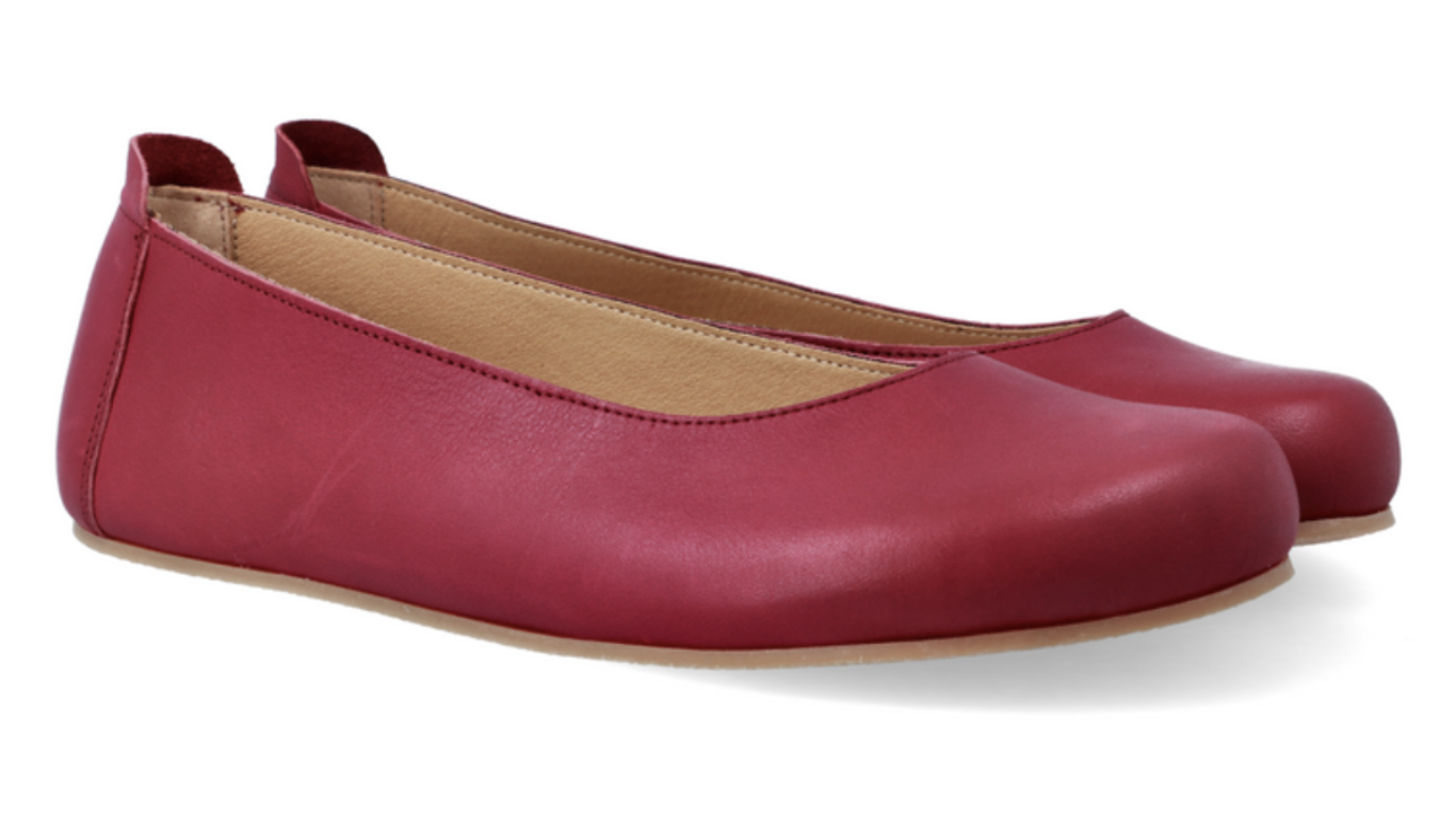 Ballerinas als Paar, schräge Vorderansicht. Glattes Leder, runde Zehenform, sehr flache Sohle.