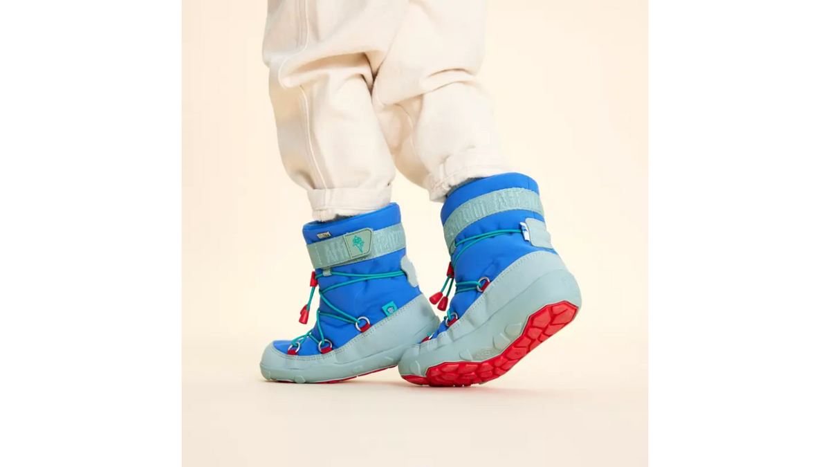 Kinder-Barfußwinterstiefel getragen am Fuß mit geschlossener Ferse, hohem Schaft, Schnürsystem mit Kordel, flexible Sohle, Detailansicht.