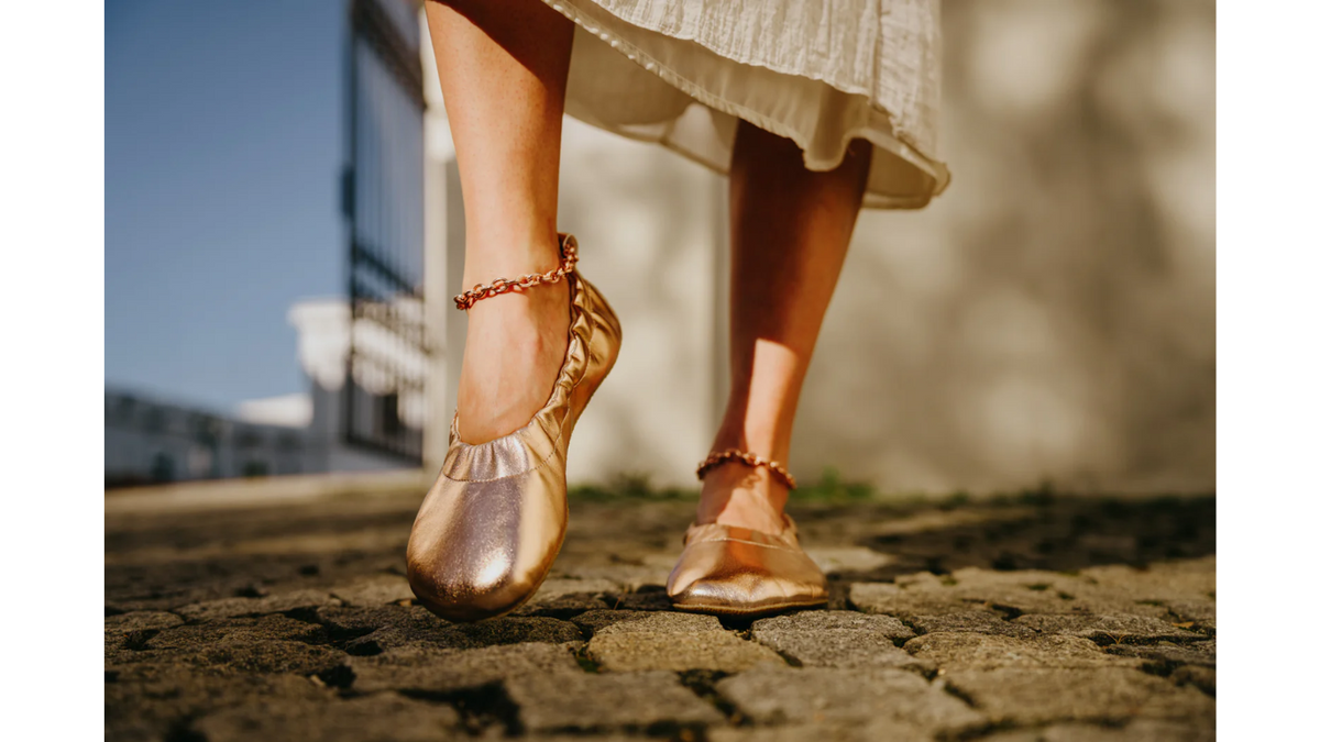 Barfußschuhe im getragenen Zustand, Ansicht von vorn unten beim Gehen. Flache Sohle, geschlossene Zehen, bodennahe Laufbewegung.