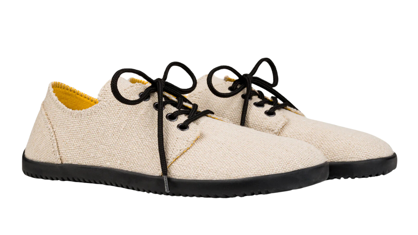 Barfußschuh, flache geschlossene Ausführung, schräge Vorderansicht als Paar. Geschlossene Zehen, bodennahe Sohle.