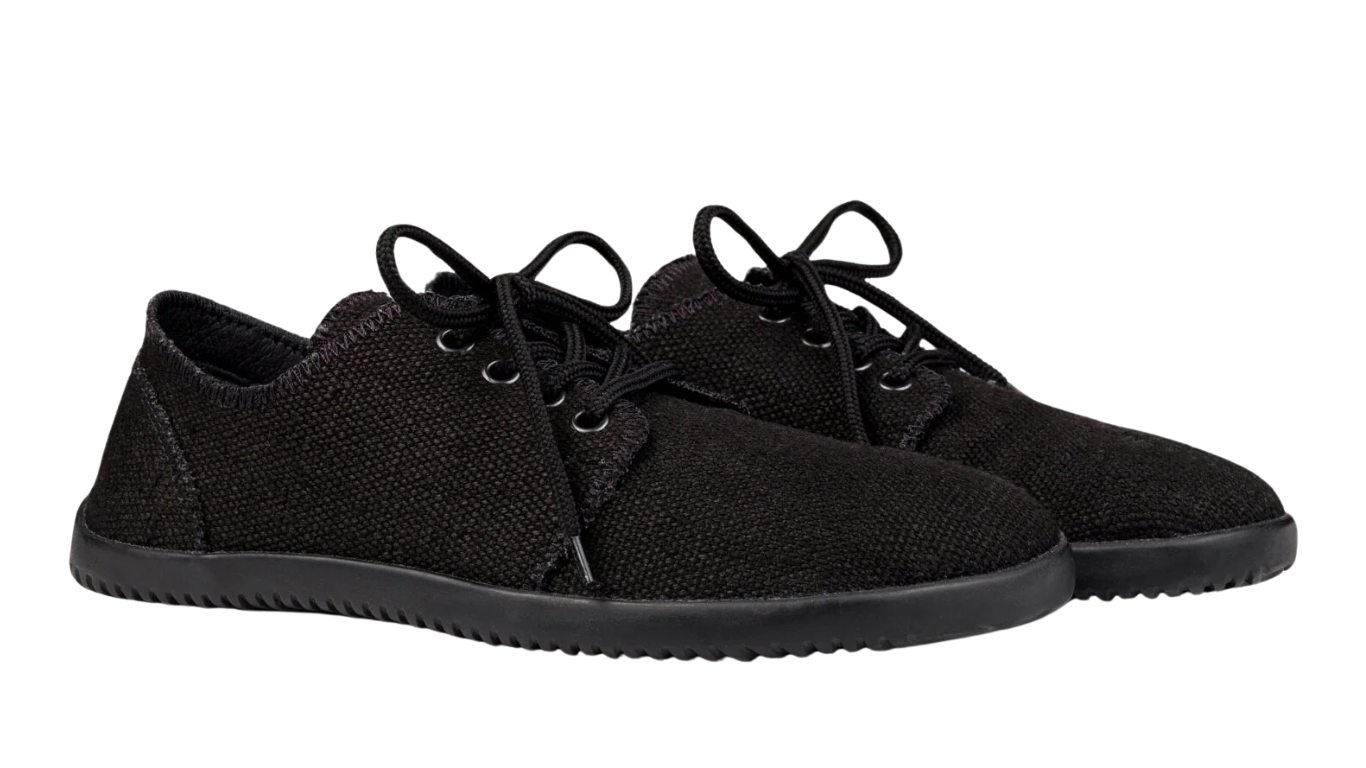 Barfußschuh, flache geschlossene Ausführung, schräge Vorderansicht als Paar. Geschlossene Zehen, bodennahe Sohle.