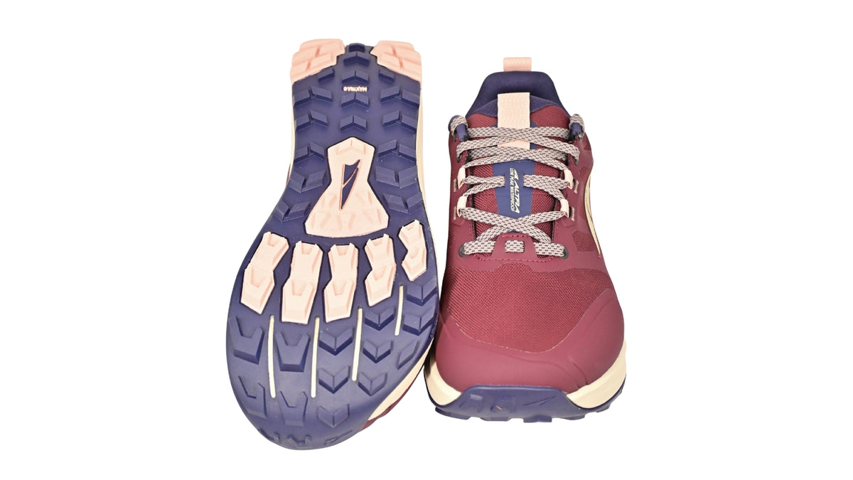 Trailrunningschuh, Ansicht von unten und seitlich als Paar. Stark profilierte Laufsohle mit ausgeprägtem Stollenmuster.