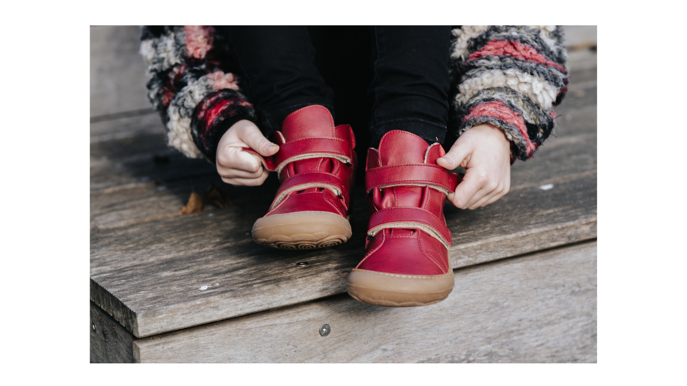 Barfußschuh für Kinder, knöchelhoch, Tragebild. Kind trägt geschlossene Schuhe mit Klettverschluss, Standposition von oben sichtbar.