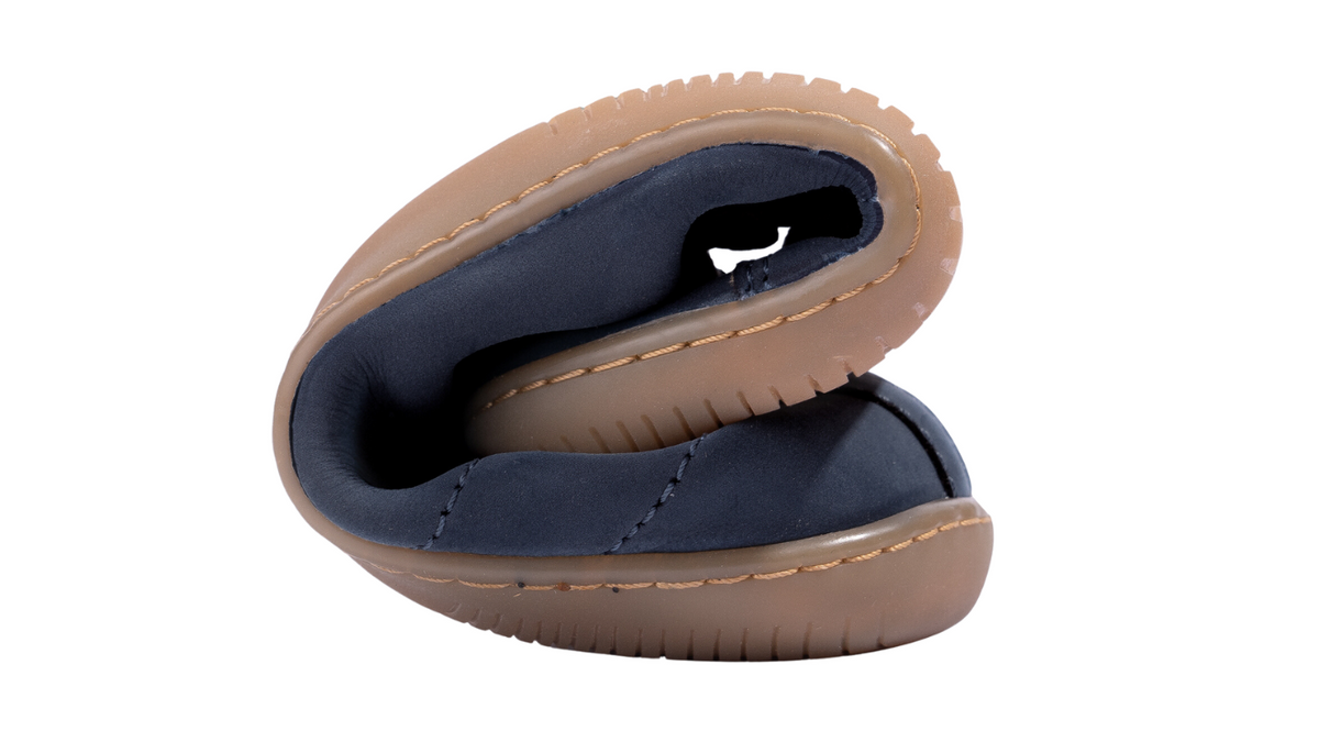 Barfußschuh, zusammengerollt dargestellt. Sehr hohe Flexibilität von Sohle und Obermaterial sichtbar.