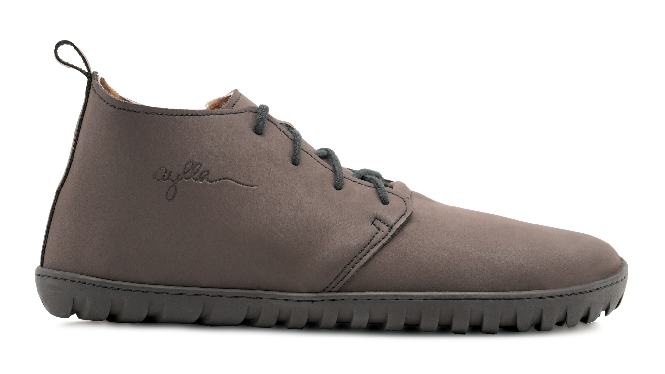 Barfußstiefel, Seitenansicht außen. Geschlossener Schuh mit Schnürung, mittelhoher Schaft, breite Zehenbox, flexible flache Sohle.