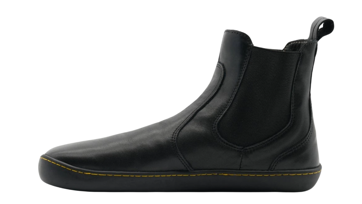 Knöchelhoher Barfußschuh, Seitenansicht innen. Geschlossene Zehen, geschlossener Fersenbereich, elastischer Einsatz, gleichmäßige Sohlenstärke.