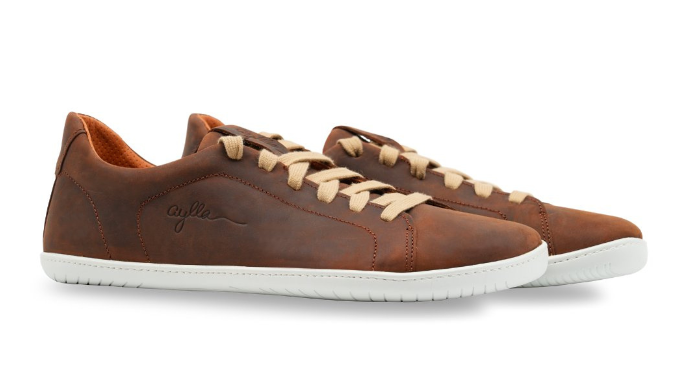 Barfußschuh für Erwachsene als Paar mit breiter Zehenbox, geschlossenem Zehenbereich, geschlossener Ferse, Schnürung, flacher flexible Sohle, schräge Vorderansicht.