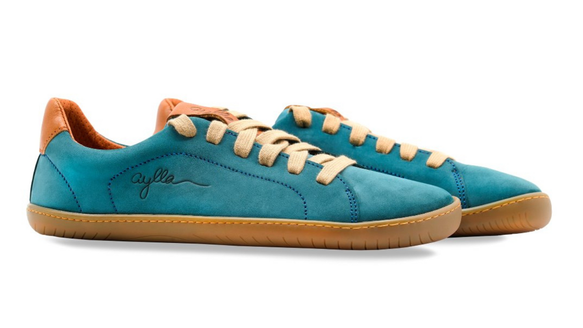 Barfußschuh für Erwachsene als Paar mit breiter Zehenbox, geschlossenem Zehenbereich, geschlossener Ferse, Schnürung, flacher flexible Sohle, schräge Vorderansicht.