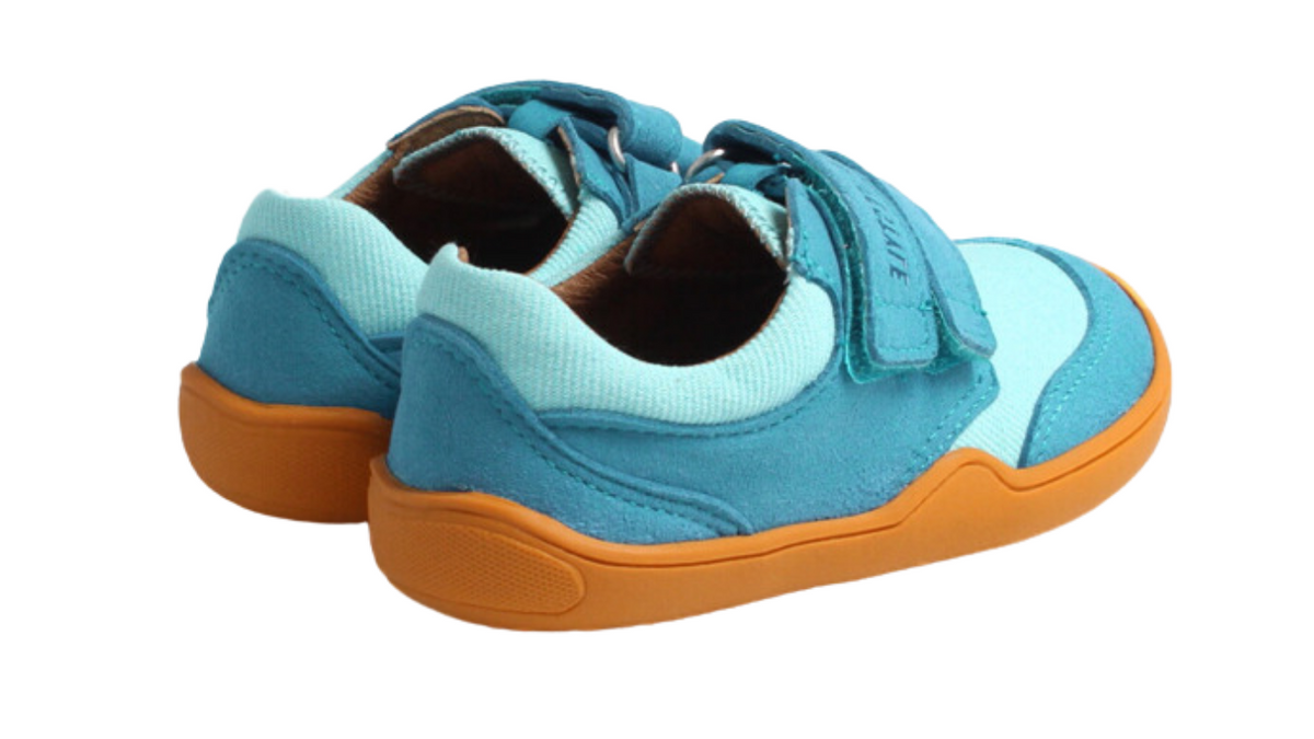 Barfußschuh für Kinder mit breiter Zehenbox, flexibler Sohle und Klettverschluss, geschlossene Zehen und geschlossener Fersenbereich, Rückansicht schräg.