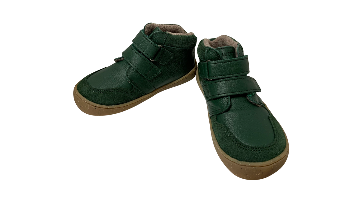 Zwei halbhohe Barfußschuhe für Kinder mit Klettverschlüssen und breiter Zehenbox, einer Seitenansicht innen, einer schräge Vorderansicht