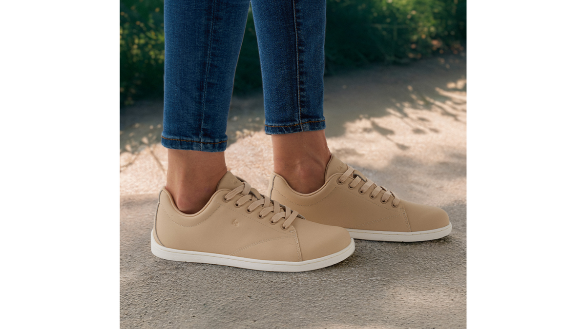 Barfußsneaker, Detailansicht. Getragene Schuhe am Fuß, Seitenansicht außen mit flacher Sohle.