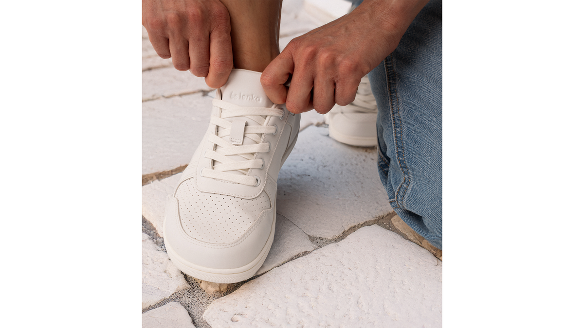 Barfußsneaker, Detailansicht. Getragener Schuh beim Binden, Draufsicht auf Schnürung und Zehenbereich.
