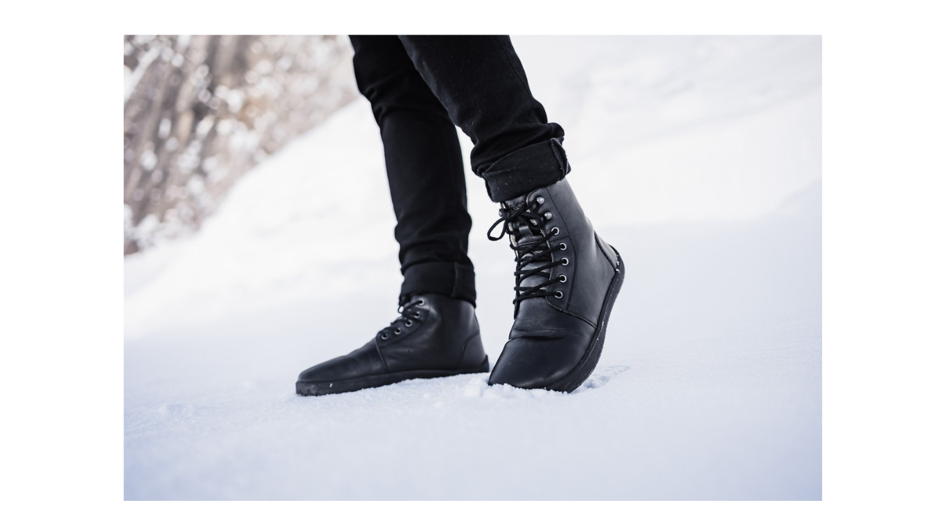 Barfußwinterstiefel für Erwachsene am Fuß getragen mit Schnürung und knöchelhohem Schaft, Seitenansicht außen.
