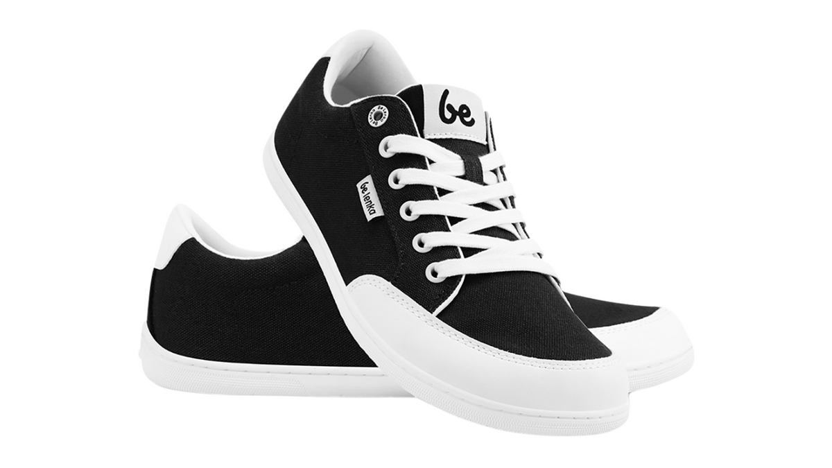Barfußsneaker, schräge Vorderansicht. Paaransicht mit Schnürung, breiter Zehenbox und flacher Sohle.