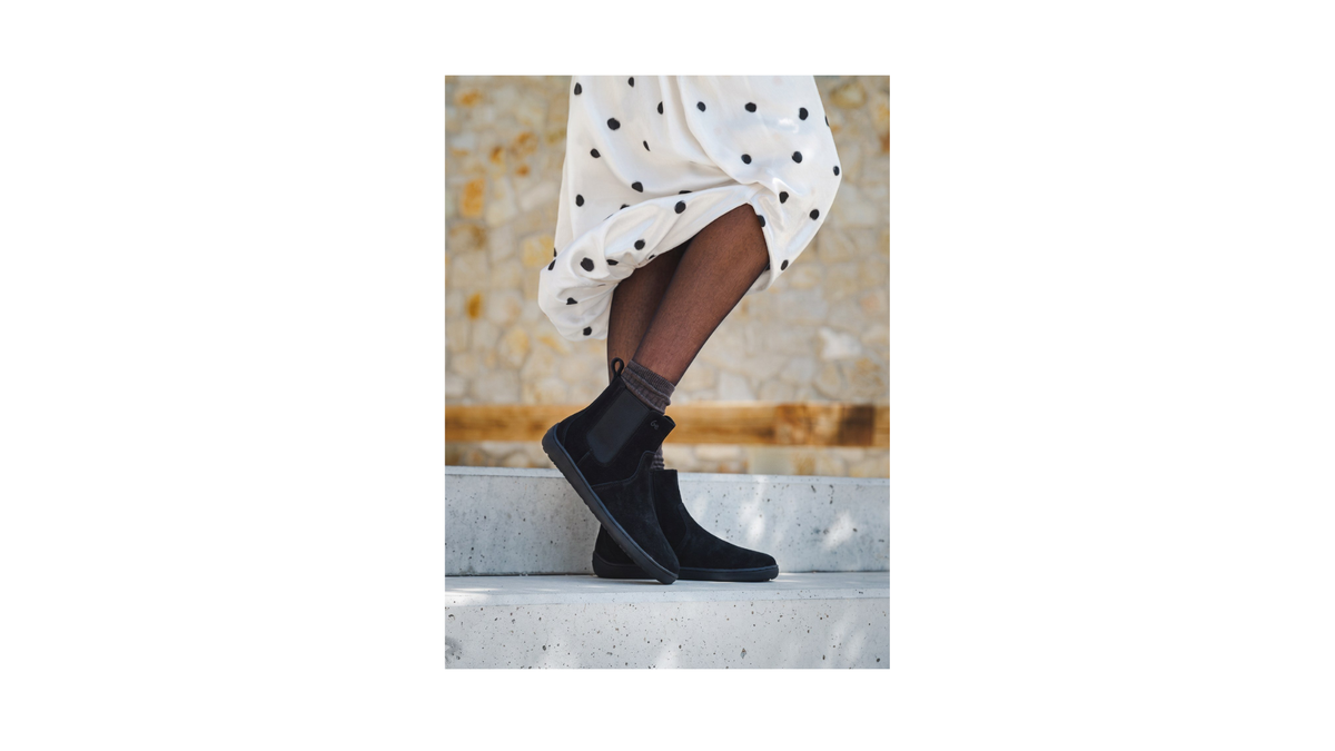 1. Gefütterte Chelsea-Barfußstiefel für Damen mit Elastikeinsätzen und flacher Sohle, am Fuß getragen, Seitenansicht außen