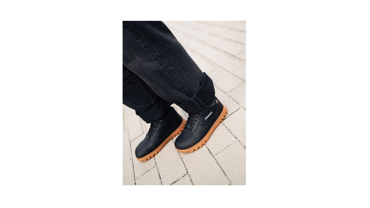 Winter-Barfußschuhe für Erwachsene mit Schnürung, knöchelhohem Schaft und profilierter Sohle, am Fuß getragen, schräge Vorderansicht