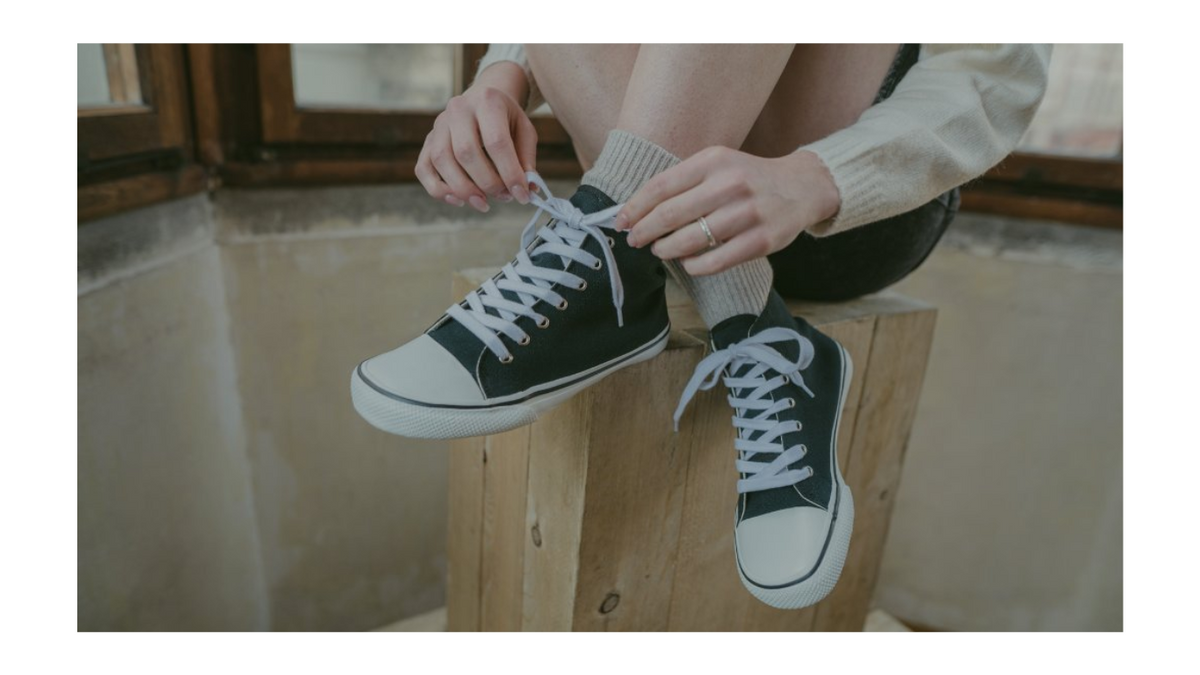 Barfußschuh für Erwachsene getragen am Fuß, mit geschlossener Ferse, Schnürung, flacher flexibler Sohle, Detailansicht.