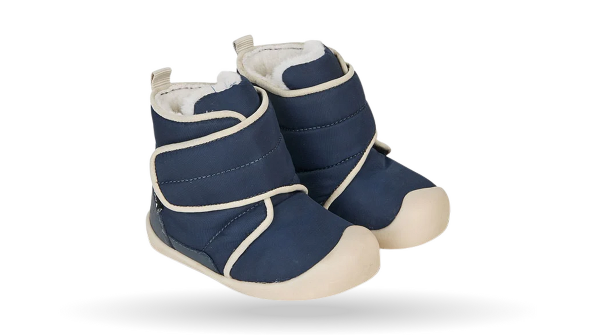 Kinder-Barfußwinterstiefel mit breiter Zehenbox, geschlossenem Zehenbereich, geschlossener Ferse, hohem Schaft, Riemenkonstruktion, flacher flexibler Sohle, schräge Vorderansicht.