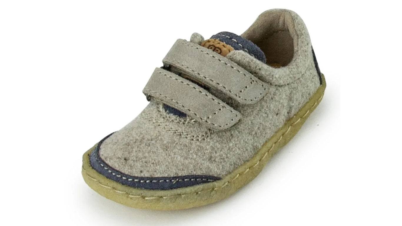 Barfußschuh für Kinder mit geschlossener Zehenbox, zwei Klettverschlüssen und flexibler Sohle. Schräge Vorderansicht.