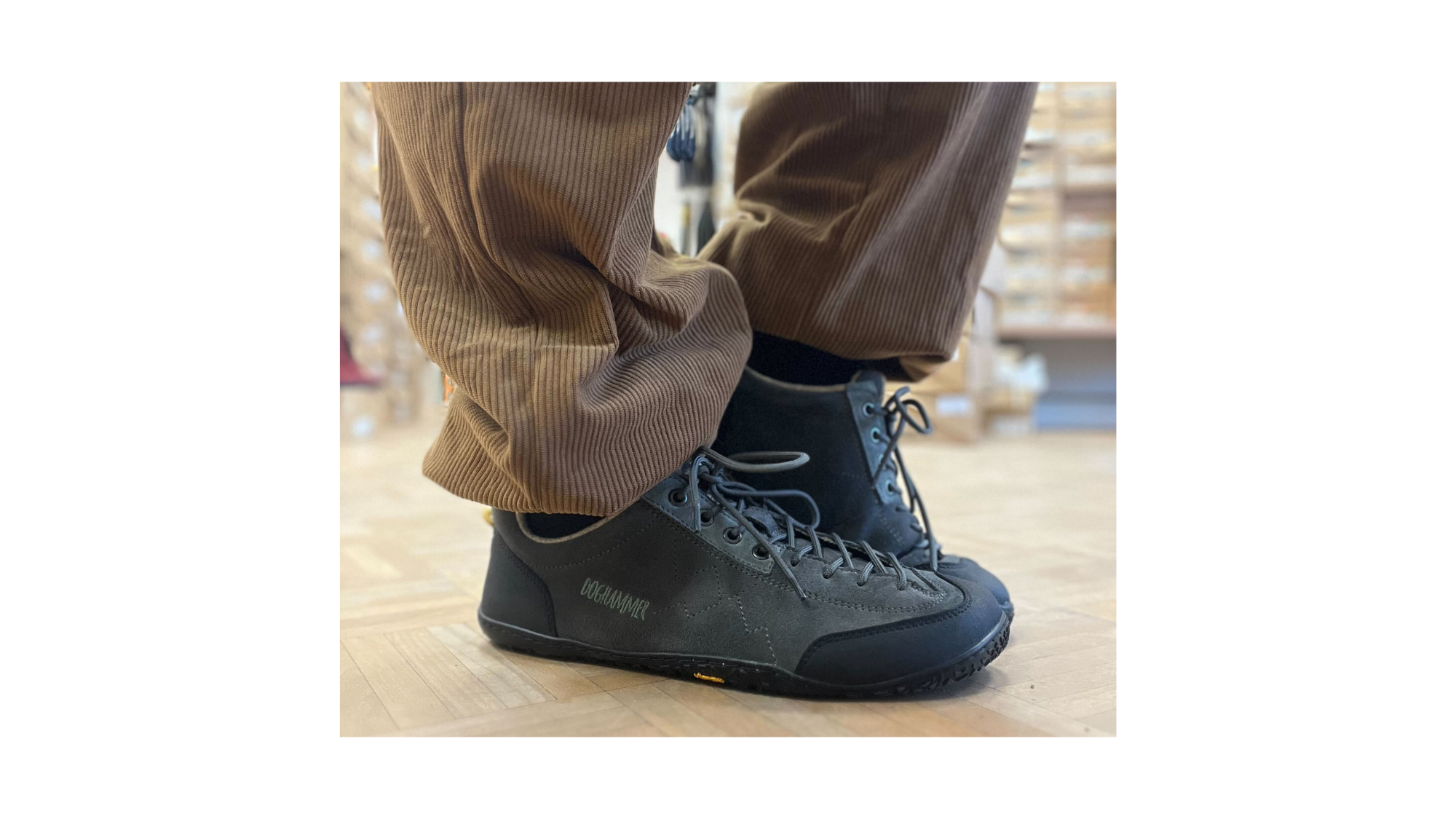 Barfuß-Wanderschuh für Erwachsene getragen am Fuß mit geschlossener Ferse, Schnürung und profilierter flexibler Sohle, Detailansicht.