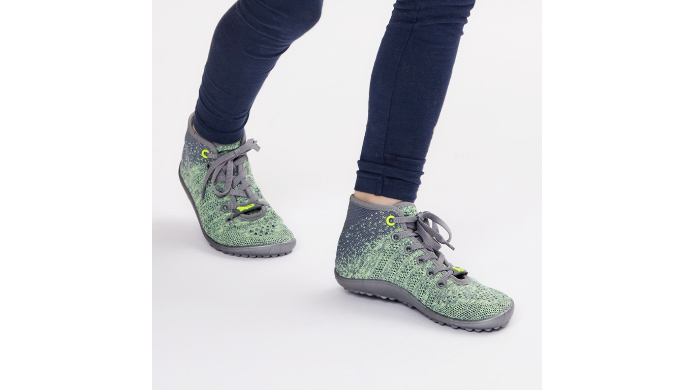 Barfußschuh für Kinder mit Schnürsenkeln, geschlossener Zehenbox und geschlossenem Fersenbereich, flexible profilierte Sohle, schräge Vorderansicht am Fuß getragen