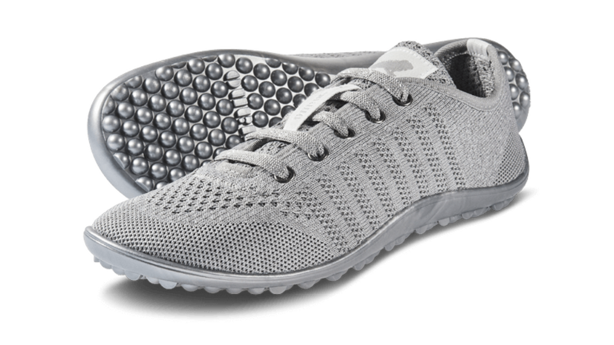 Barfußschuh mit Schnürsenkeln, geschlossener Zehenbox und geschlossenem Fersenbereich, flexible Sohle mit runden Profilnoppen, schräge Vorderansicht als Paar