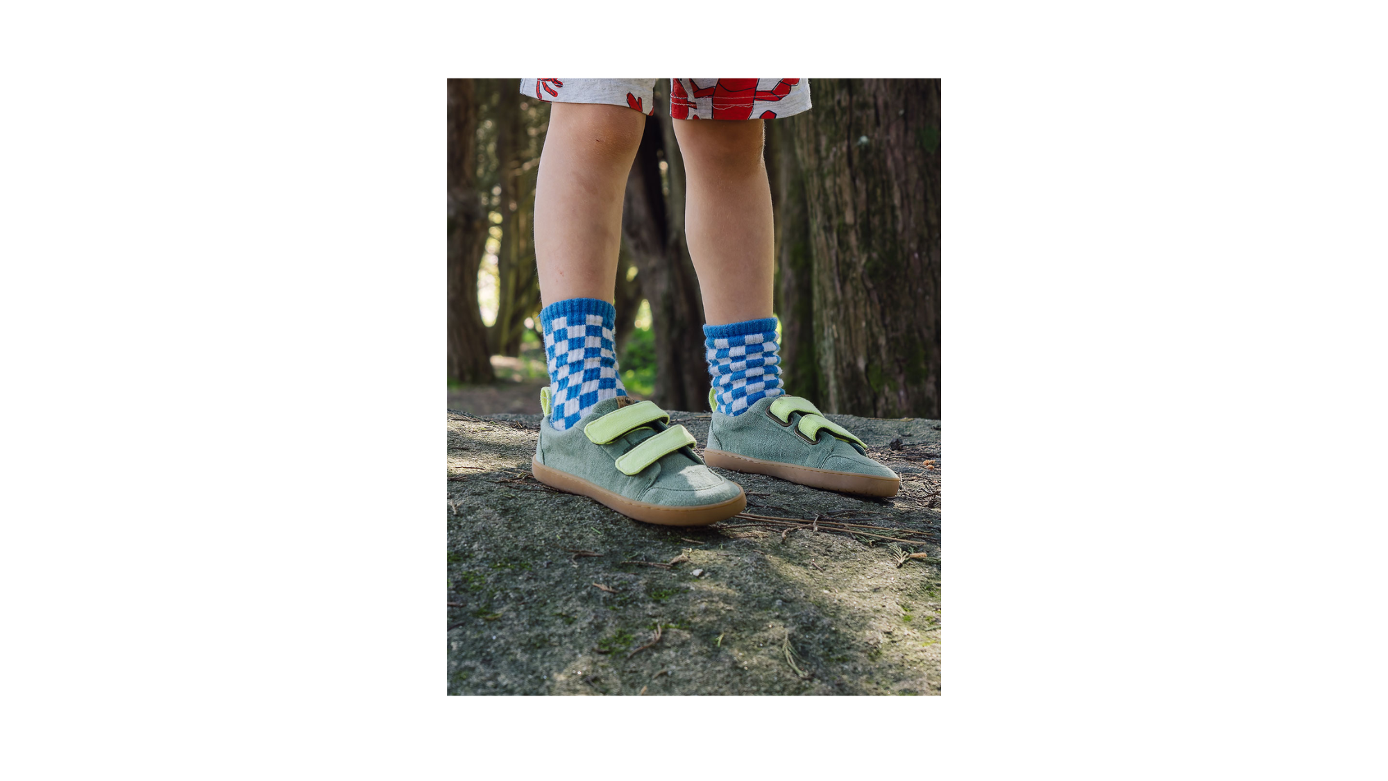 Kinder-Barfußsneaker mit zwei Klettverschlüssen und geschlossener Zehenpartie, schräge Vorderansicht als Paar, getragen am Fuß