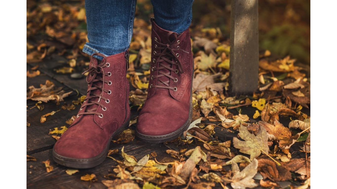 Barfußstiefel mit Schnürverschluss am Fuß getragen, breiter Zehenbox und flacher Sohle, geschlossener Fersenbereich, schräge Vorderansicht