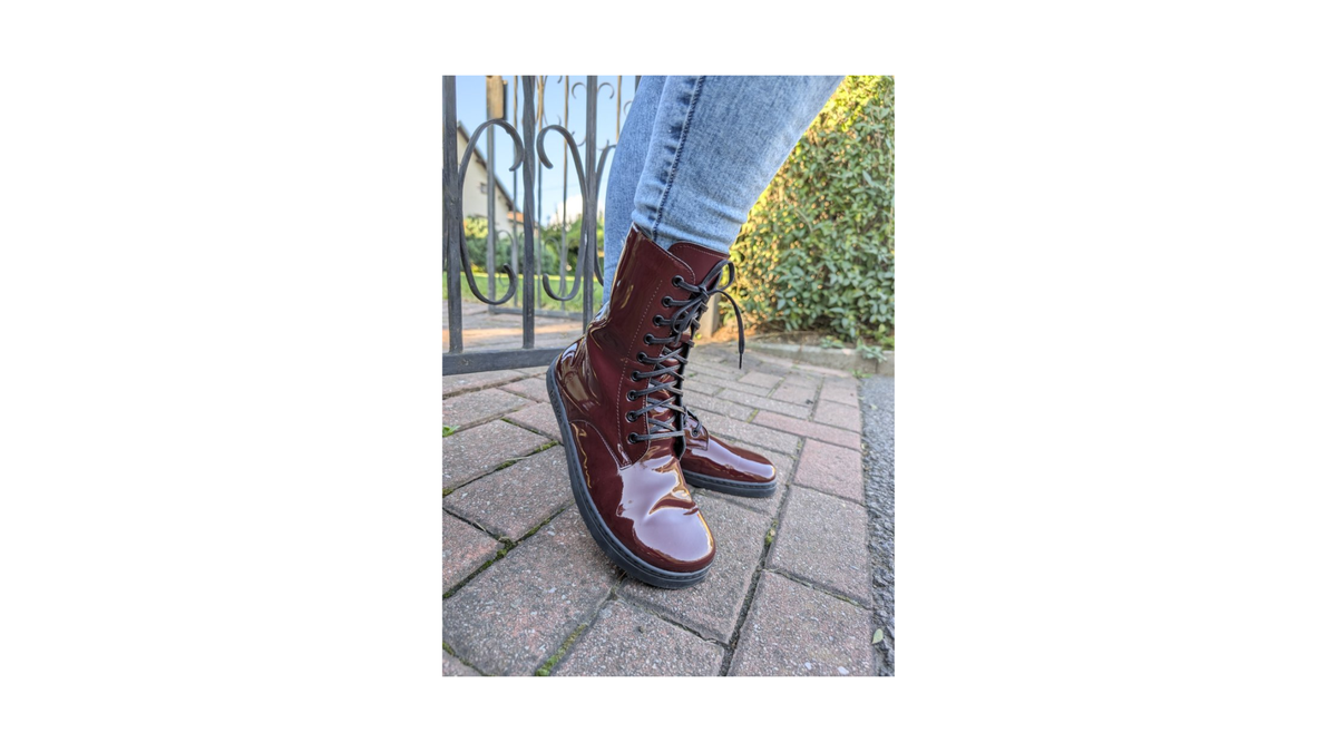 Barfußstiefel für Erwachsene, geschlossene Zehenpartie, geschlossener Fersenbereich, Schnürung, mittelhoher Schaft, flache Sohle, schräge Vorderansicht als Paar, getragen am Fuß