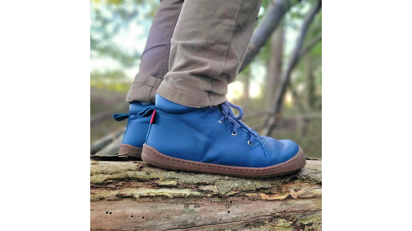 Kinder Barfußschuhe mit breiter Zehenbox, flexibler Sohle und Schnürung, geschlossene Zehen und geschlossener Fersenbereich, Paar, schräge Vorderansicht, am Fuß getragen