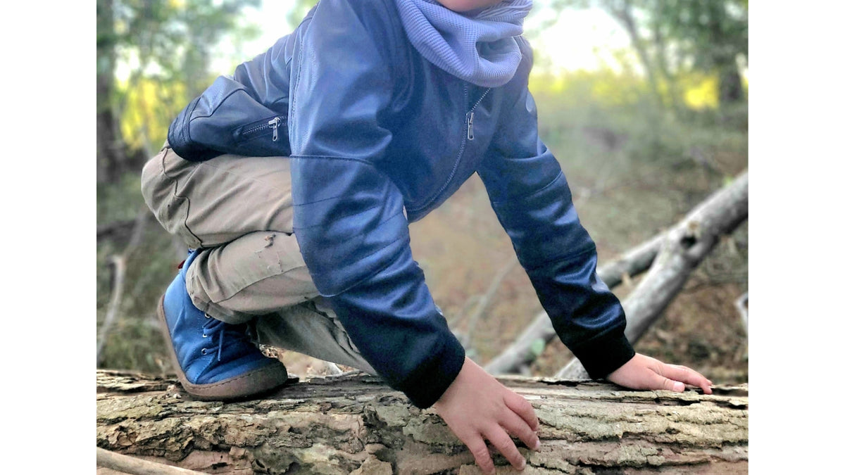 Kinder Barfußschuhe mit breiter Zehenbox, flexibler Sohle und Schnürung, geschlossene Zehen und geschlossener Fersenbereich, Paar, schräge Vorderansicht, am Fuß getragen