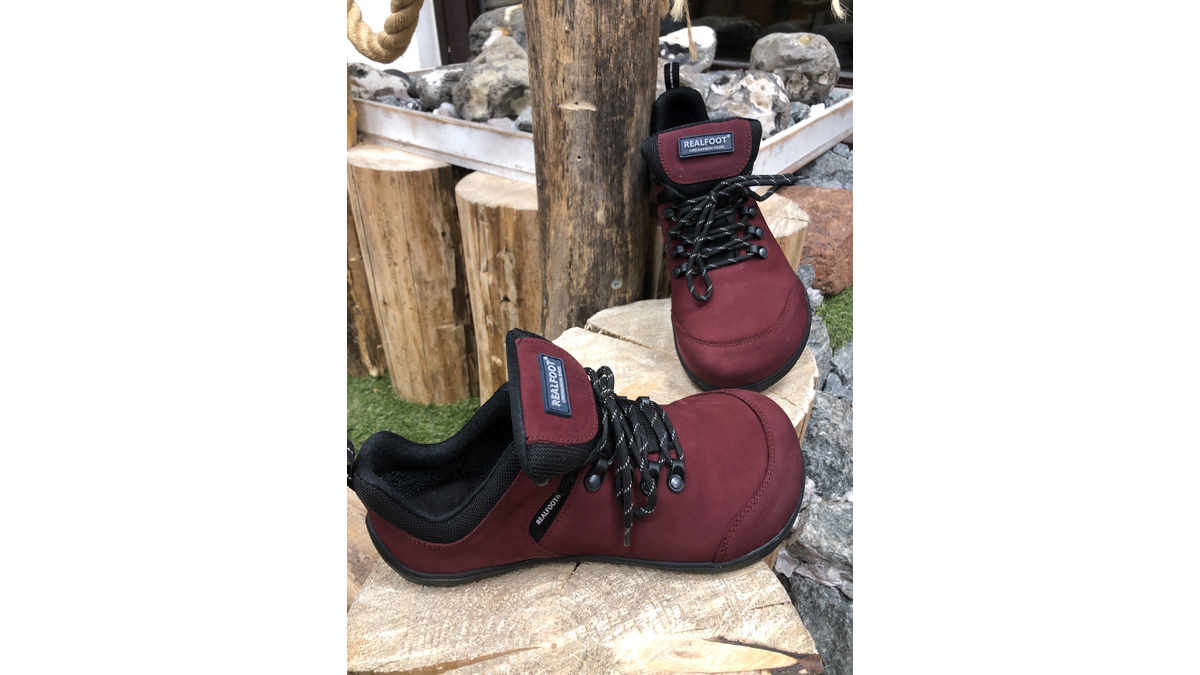 Barfußschuh mit Schnürung, breite Zehenbox, flache flexible Sohle, geschlossener Fersenbereich, getragen am Fuß, schräge Vorderansicht