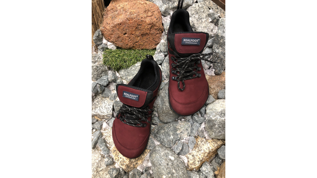 Barfußschuh mit Schnürung, breite Zehenbox, flache flexible Sohle, geschlossener Fersenbereich, getragen am Fuß, schräge Vorderansicht