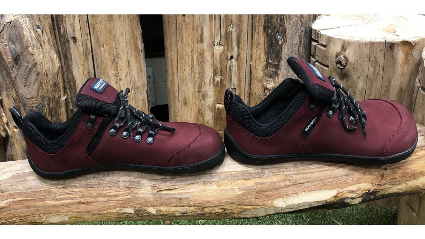 Barfußschuh mit Schnürung, breite Zehenbox, flache flexible Sohle, geschlossener Fersenbereich, getragen am Fuß, schräge Vorderansicht