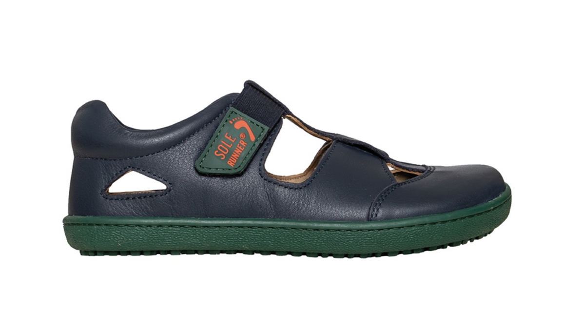 Kinder Barfußsandale, geschlossene Zehen und geschlossener Fersenbereich, zwei Klettverschlüsse und Riemen, flexible Sohle, einzelner Schuh, Seitenansicht außen