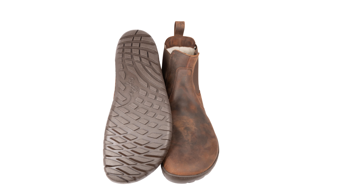 Chelsea-Boot, Ansicht von unten und schräg von hinten. Profilierte, flexible Laufsohle, flacher Fersenbereich ohne Sprengung.