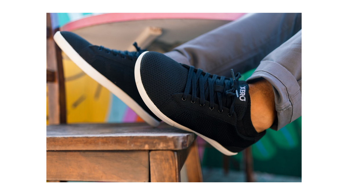 Barfußschuh mit Schnürung, breite Zehenbox, flexible Sohle, geschlossener Fersenbereich, schräge Vorderansicht als Paar, getragen am Fuß