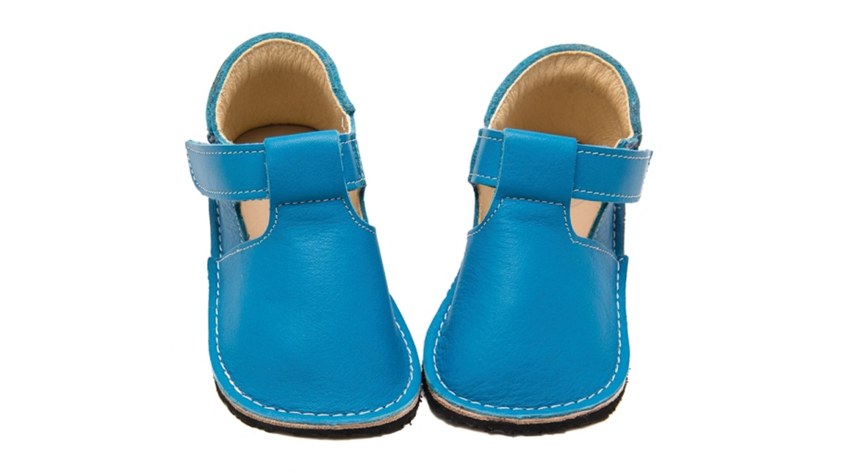 Lauflernschuhe für Kleinkinder mit breiter Zehenbox, geschlossenem Vorderfuß, Riemen und seitlichen Aussparungen, schräge Vorderansicht