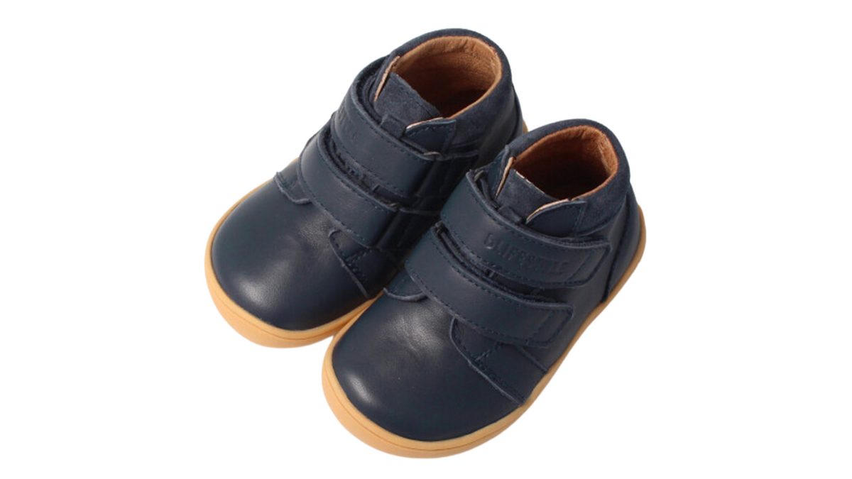 Knöchelhoher Barfußschuh für Kinder mit breiter Zehenbox, Klettverschluss, geschlossenen Zehen, geschlossenem Fersenbereich, schräge Vorderansicht als Paar.