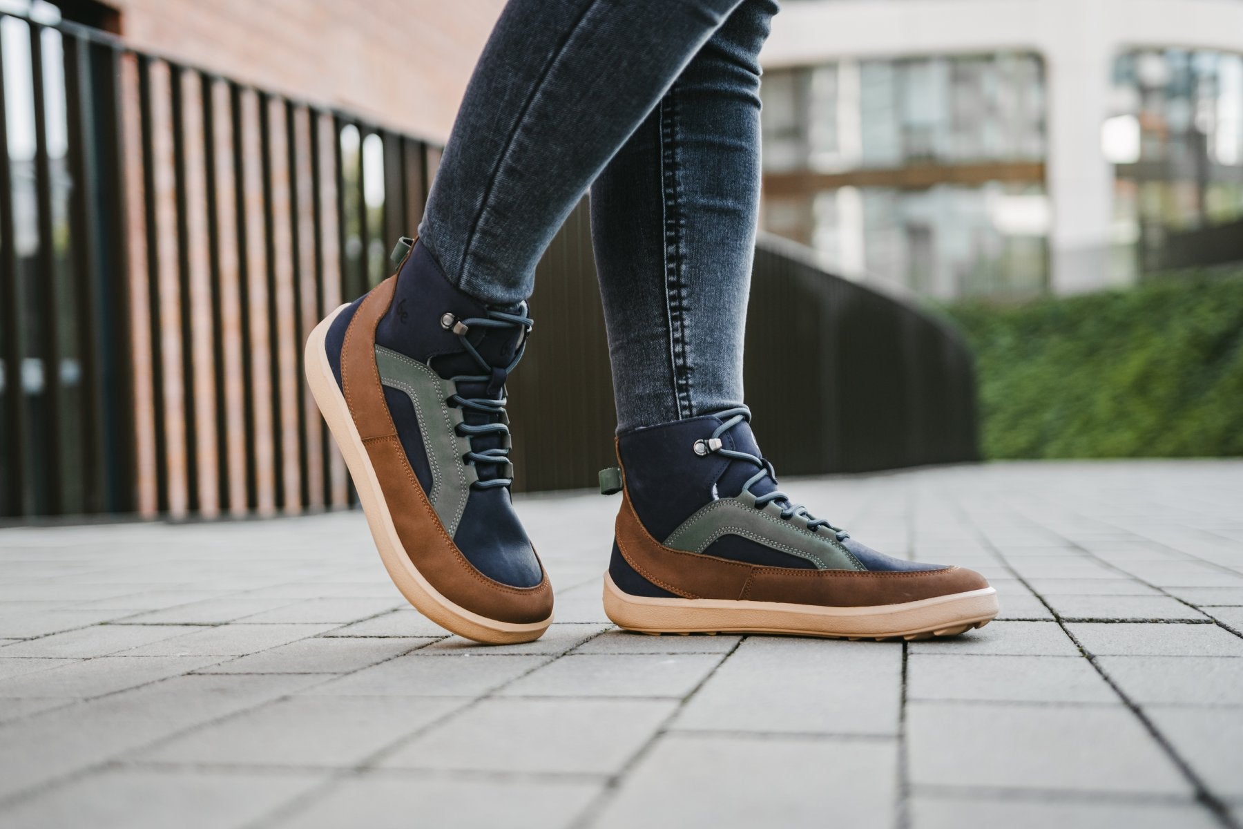 Barfußwinterstiefel für Erwachsene am Fuß getragen mit knöchelhohem Schaft, geschlossener Zehenbox und geschlossener Ferse, schräge Vorderansicht.