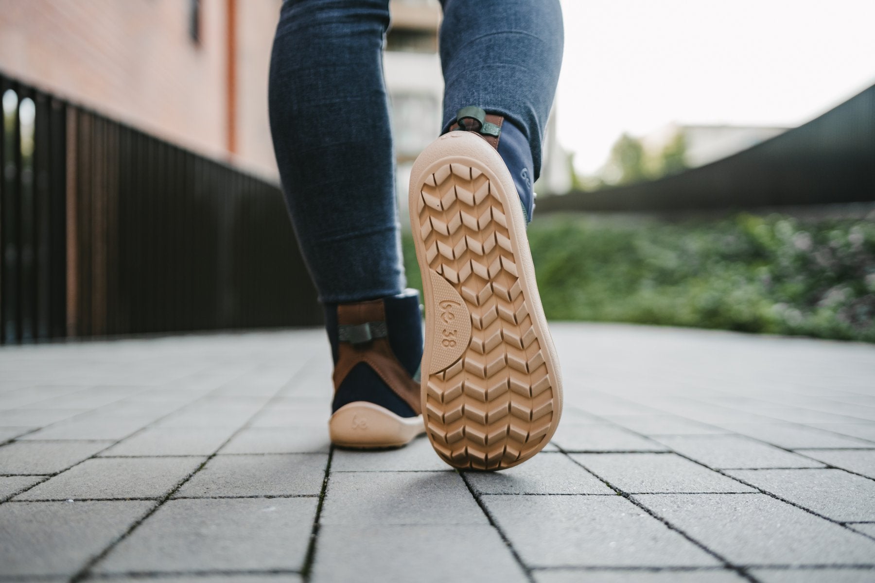 Barfußwinterstiefel für Erwachsene am Fuß getragen mit profilierter, flexibler Sohle, Ansicht von unten.