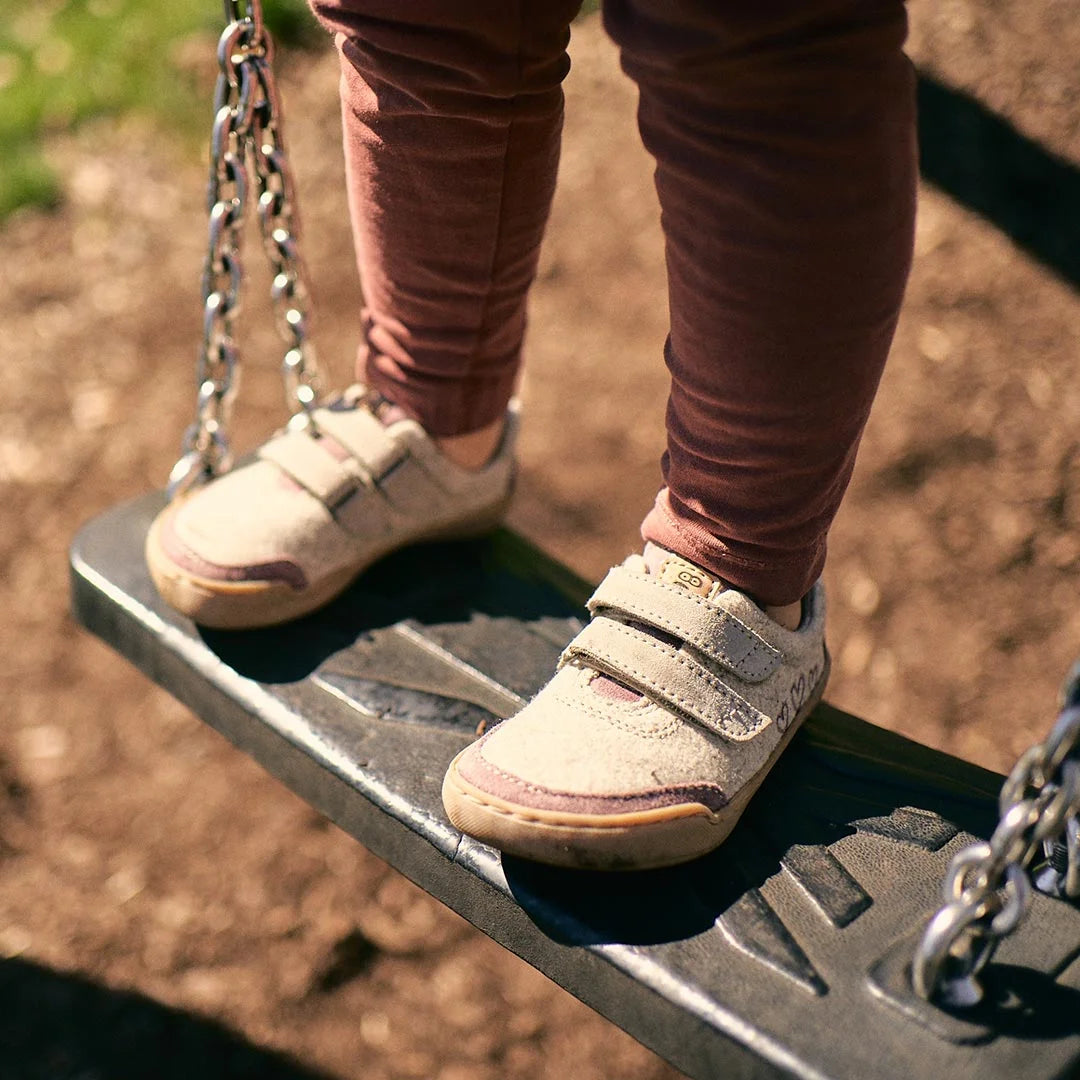 Barfußschuh für Kinder mit geschlossener Zehenbox und Klettverschlüssen, am Fuß getragen. Schräge Vorderansicht.