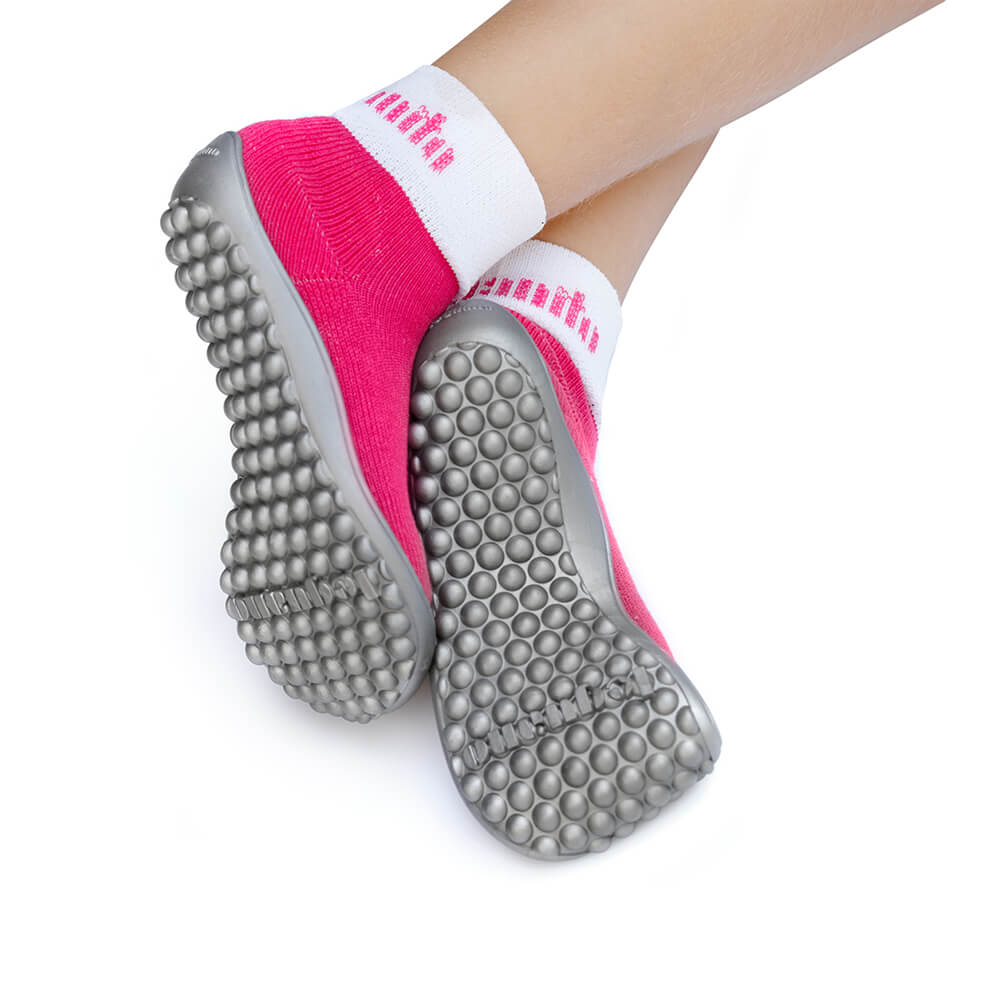 Barfußschuh mit geschlossener Zehenbox und geschlossenem Fersenbereich, elastischer Schaft ohne Verschluss, flexible Sohle mit runden Profilnoppen, Ansicht von unten am Fuß getragen