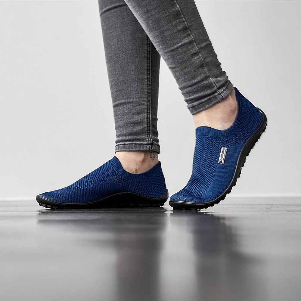 Barfußschuh mit geschlossener Zehenbox und geschlossenem Fersenbereich, elastischer Einstieg ohne Verschluss, flexible profilierte Sohle, schräge Vorderansicht am Fuß getragen