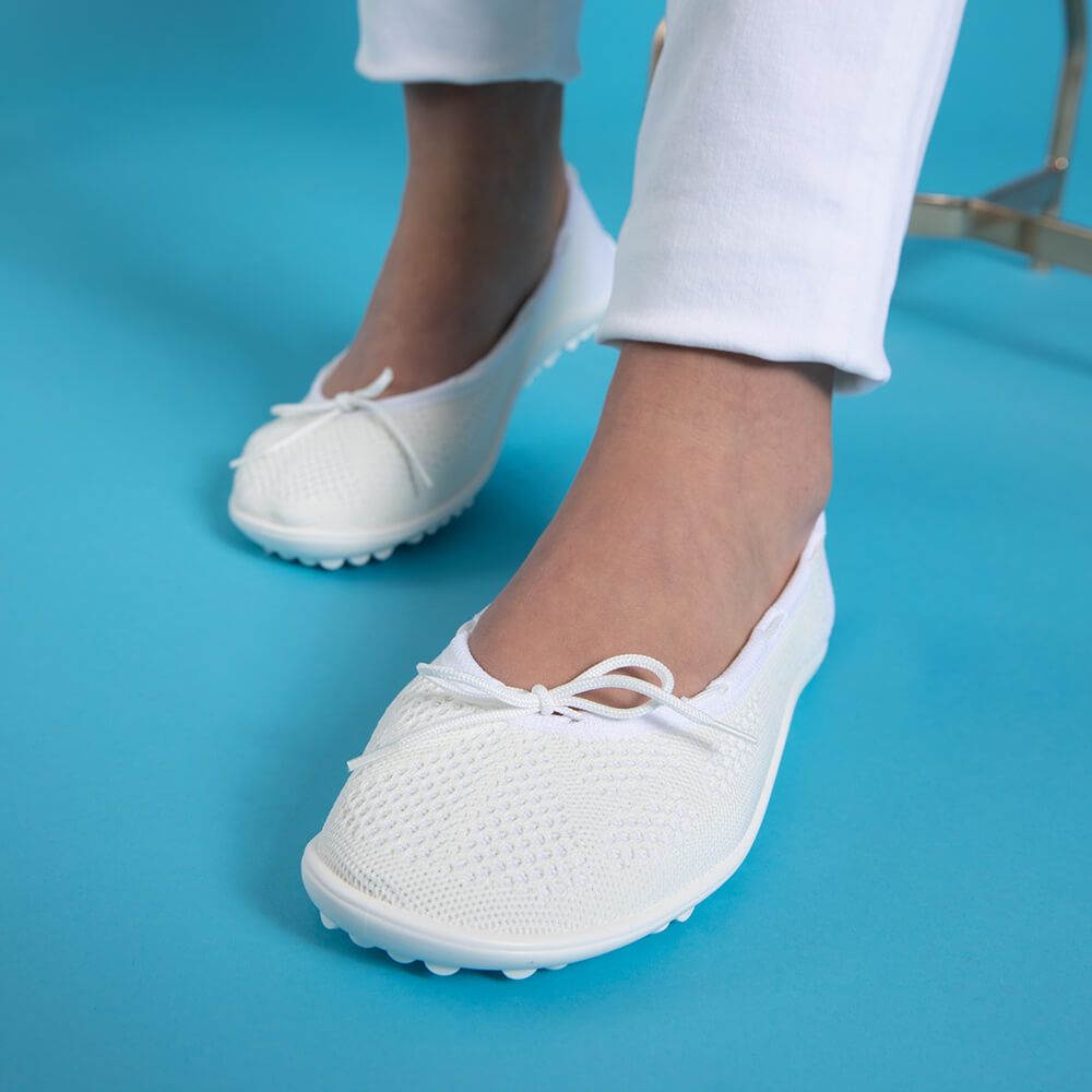 Barfußschuh mit geschlossener Zehenbox und geschlossenem Fersenbereich, elastischer Einstieg mit Schleife, flexible profilierte Sohle, schräge Vorderansicht am Fuß getragen