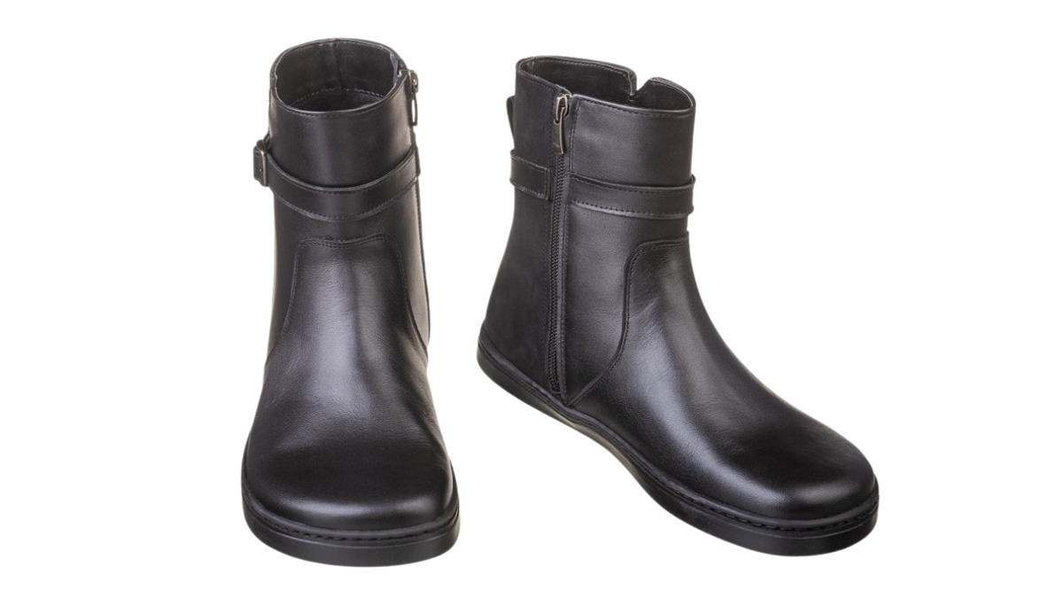 Barfußstiefel als Paar mit seitlichem Reißverschluss und Riemen, breiter Zehenbox und flacher Sohle, geschlossener Fersenbereich, schräge Vorderansicht