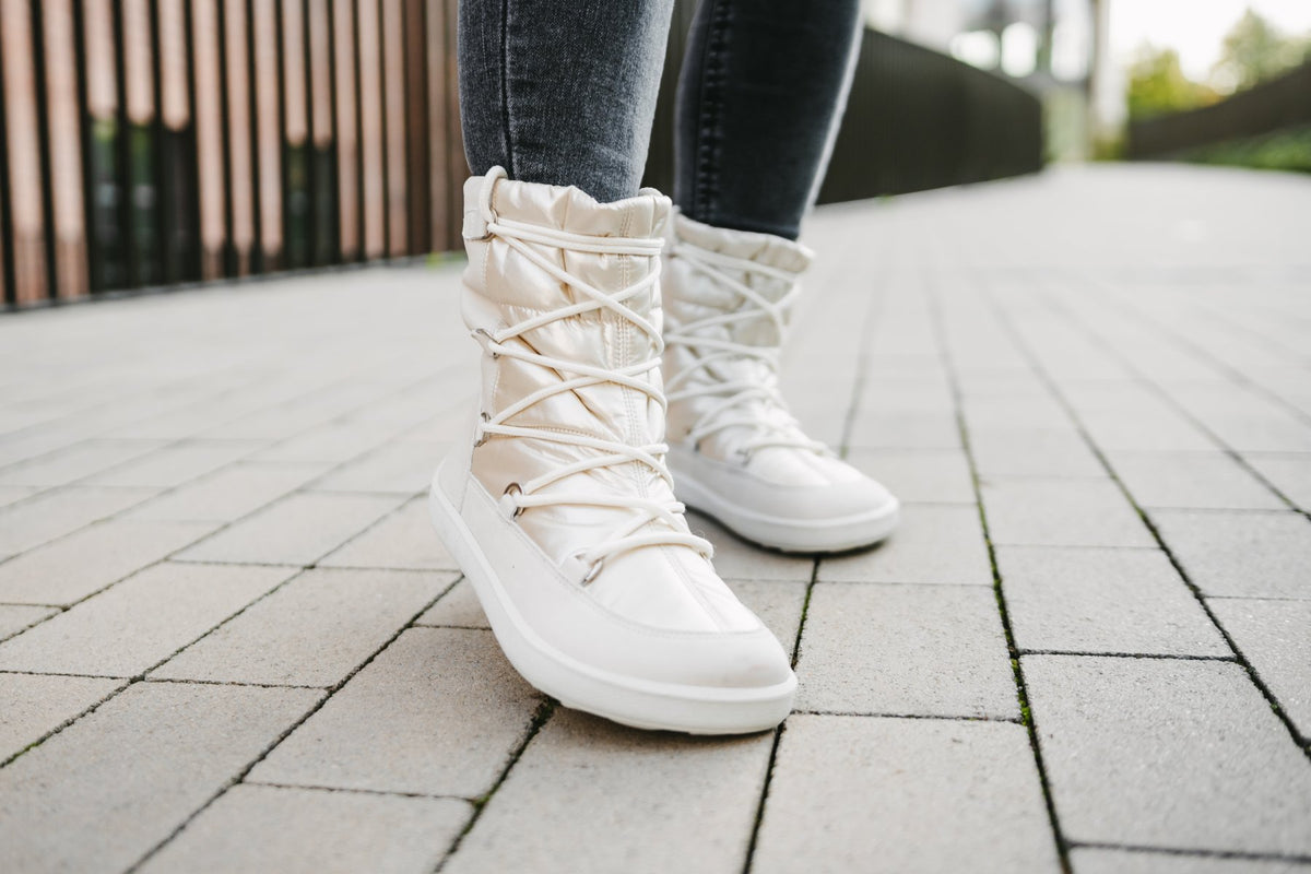 Barfußwinterstiefel für Erwachsene am Fuß getragen mit knöchelhohem Schaft und geschlossener Ferse, schräge Vorderansicht.